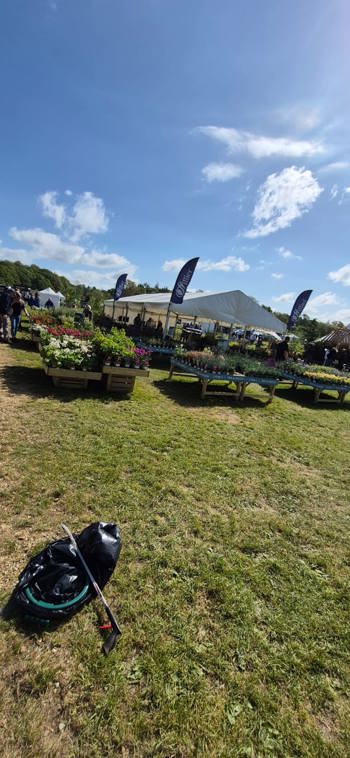 Bin Bag And Grabber Infront Of Flowers