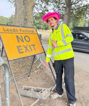 Crew Member By No Exit Sign Wearing Hat